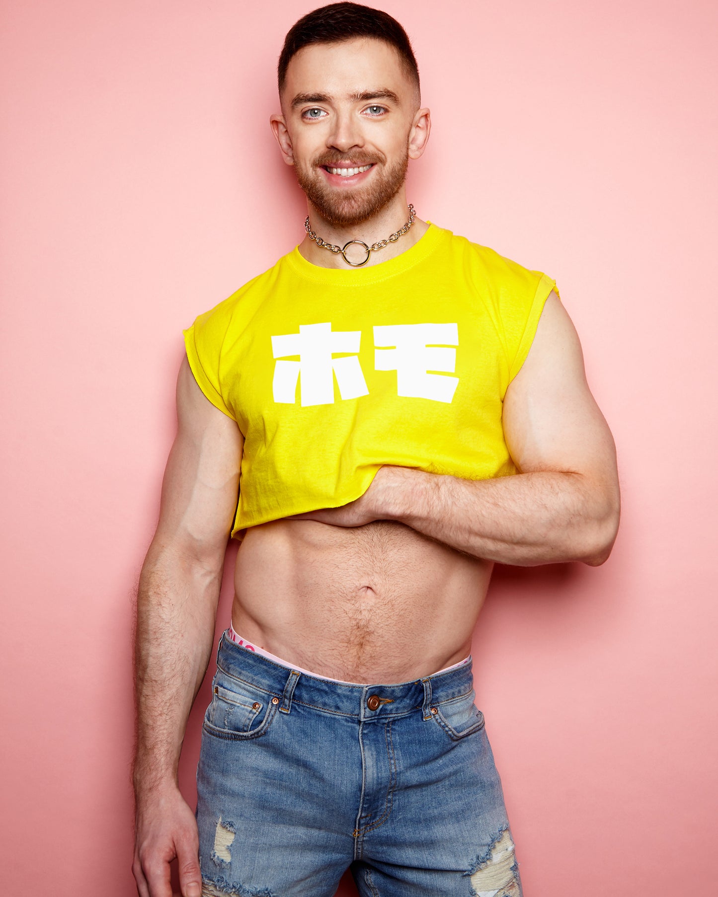 HOMO in Japanese in white on yellow sleeveless crop-top.